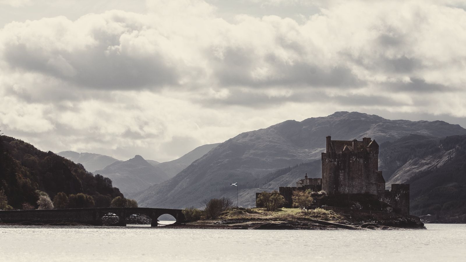 A castle on a loch under heavy cloud