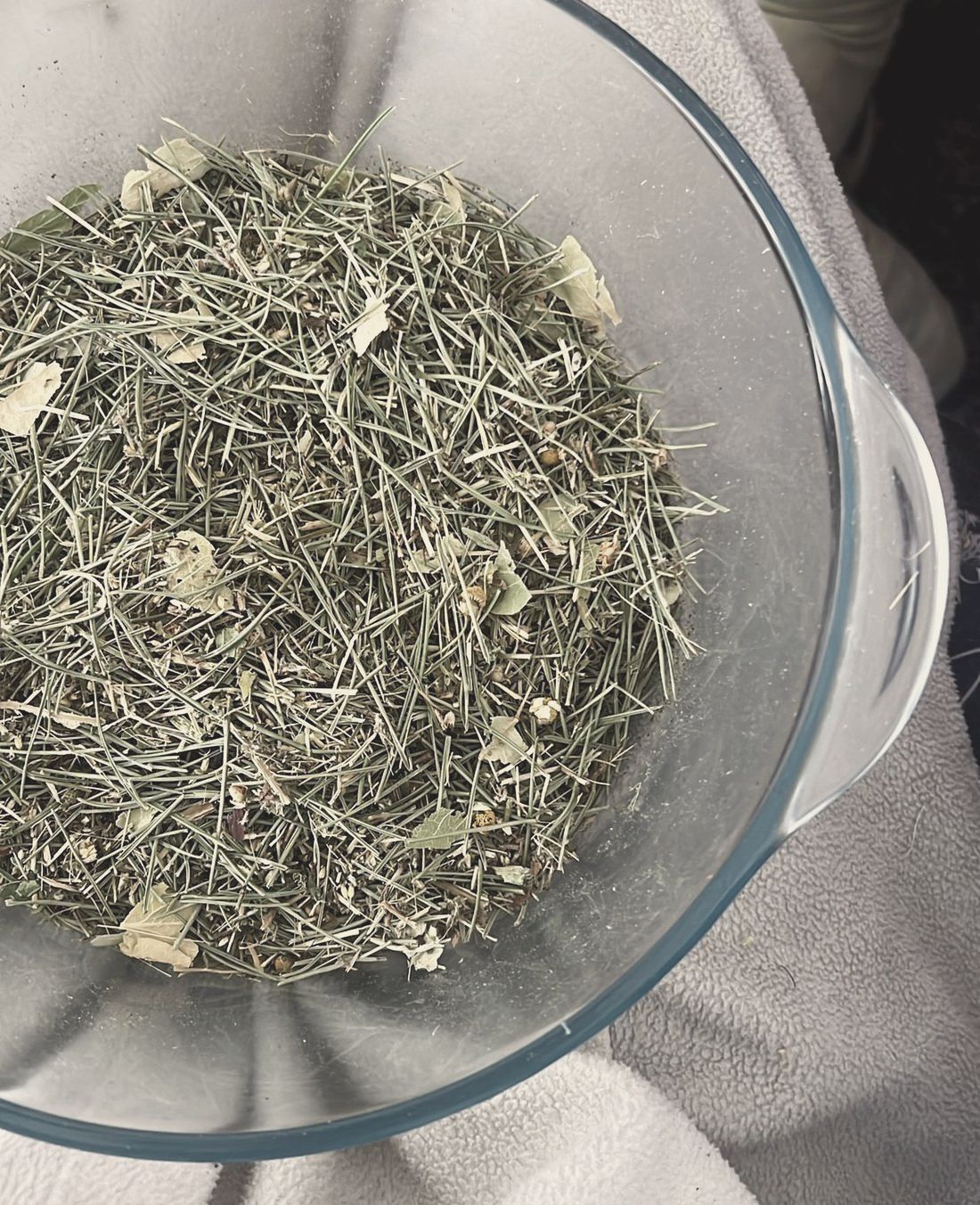 A glass bowl of dried herbs