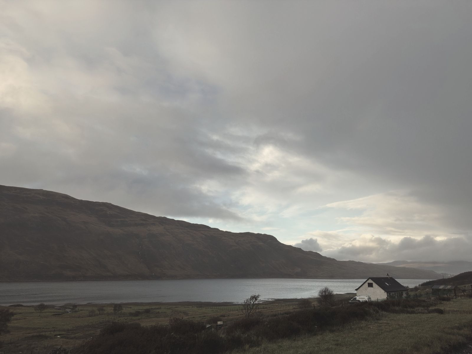 A white cottage by a loch