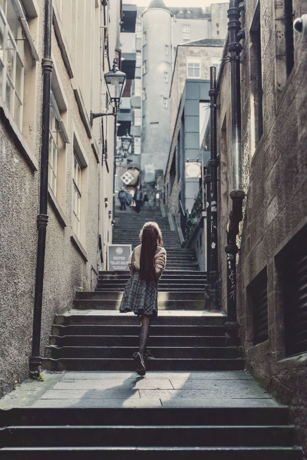 Climbing old stone steps between tall buildings