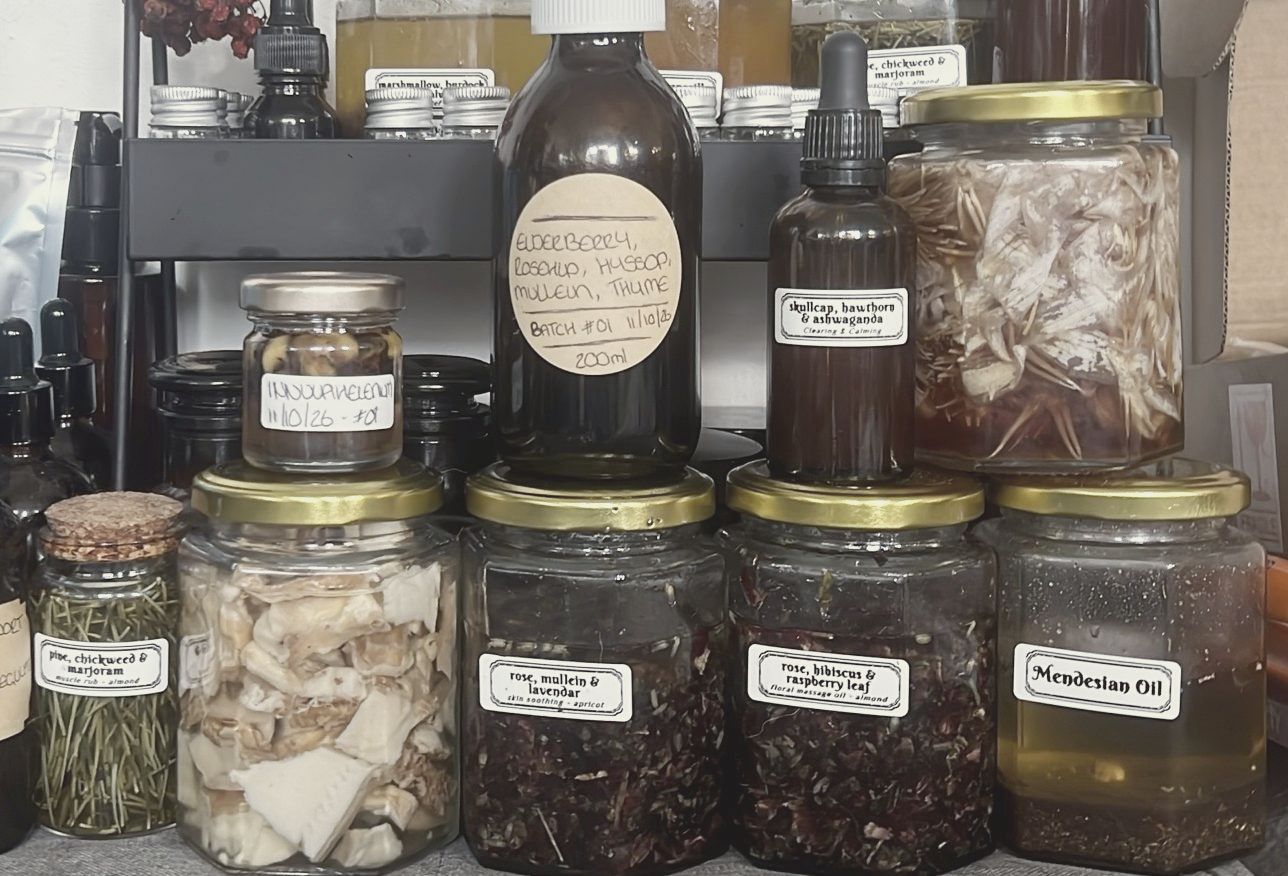 Jars of infused oils and dried herbs on my shelf
